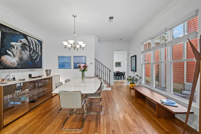 a view of a dining room with furniture a chandelier and wooden floor