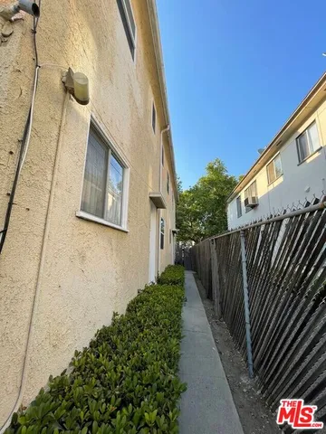 a view of a pathway of a building with wooden fence