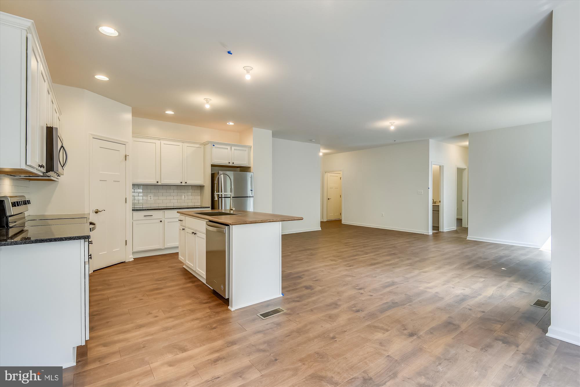 1 Ac Corner Road Sumerduck, VA 22742 - Photo 6 of 31 a kitchen with kitchen island sink stove and white cabinets