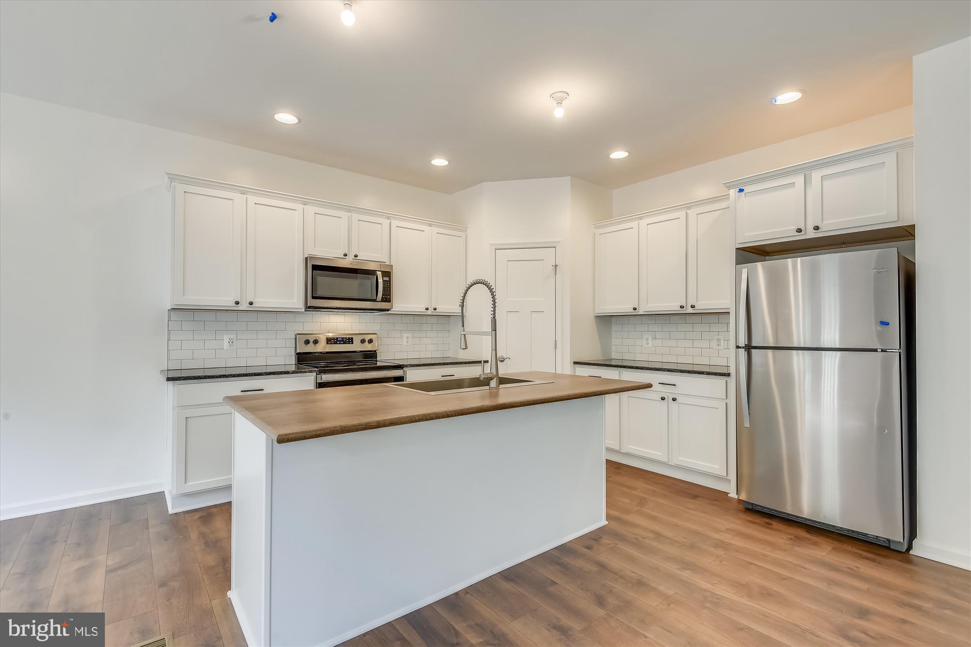 1 Ac Corner Road Sumerduck, VA 22742 - Photo 7 of 31 a kitchen with stainless steel appliances granite countertop a refrigerator a sink a stove a microwave and white cabinets