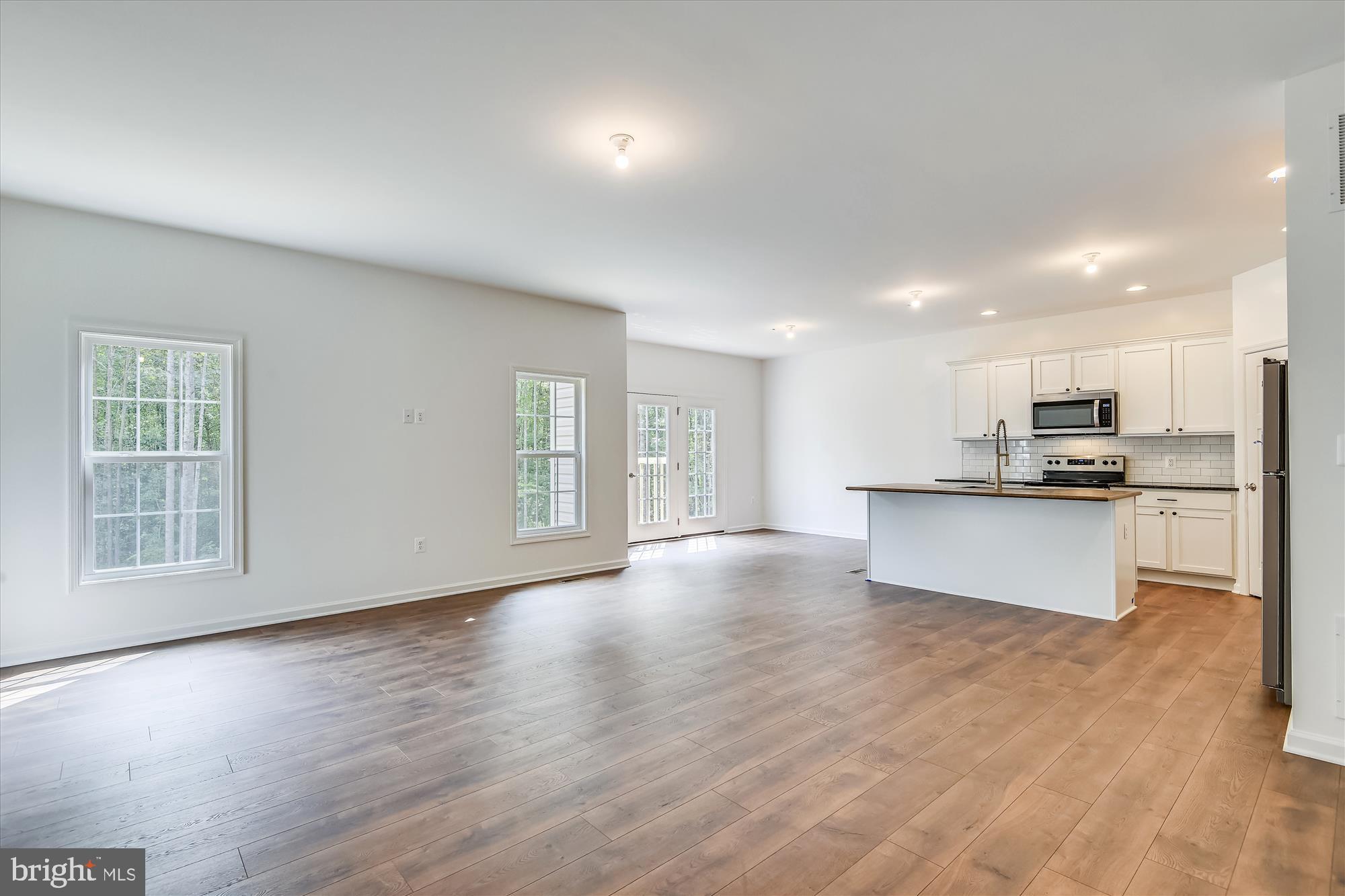 1 Ac Corner Road Sumerduck, VA 22742 - Photo 10 of 31 a view of kitchen with kitchen island granite countertop a stove top oven a sink and white cabinets with wooden floor