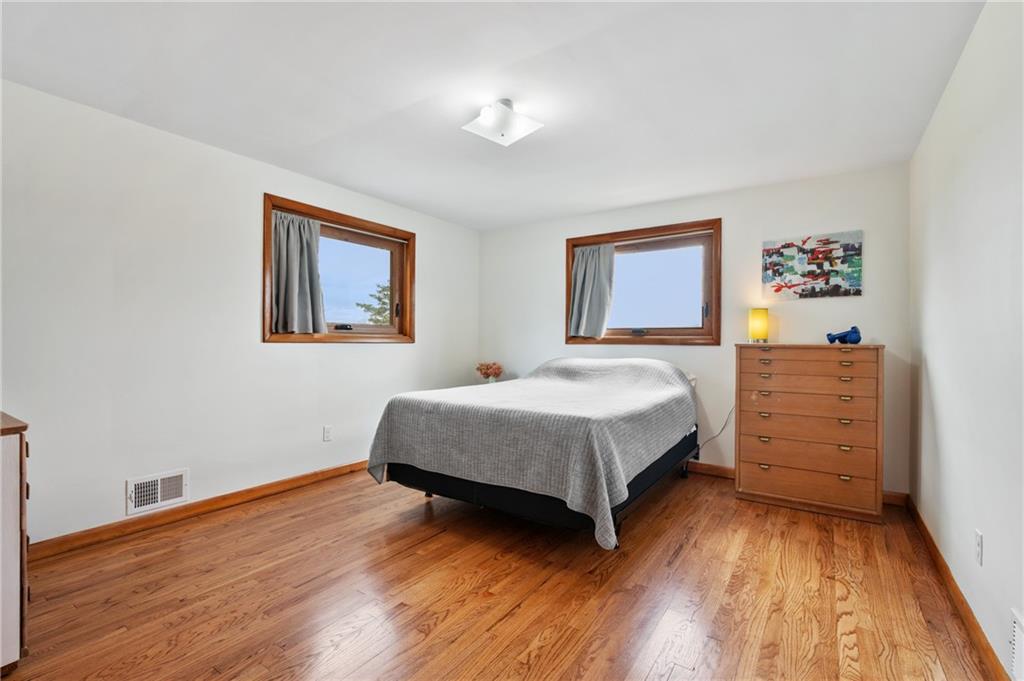 419 Amherst Avenue Coraopolis, PA 15108 - Photo 19 of 29 a spacious bedroom with a bed and a painting on the wall