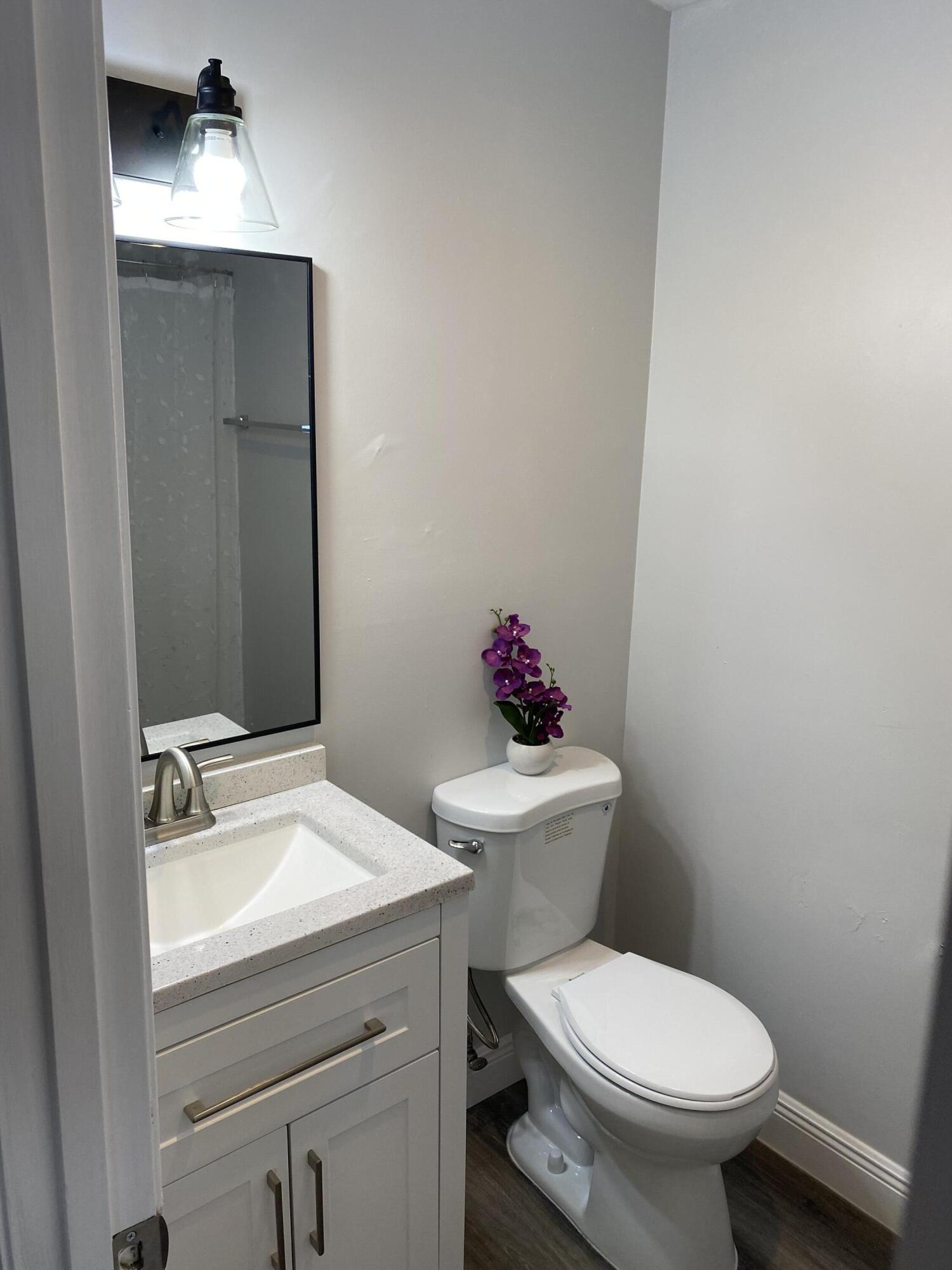 103 Southeast Norfolk Boulevard Stuart, FL 34997 - Photo 28 of 34 a bathroom with a toilet sink and mirror