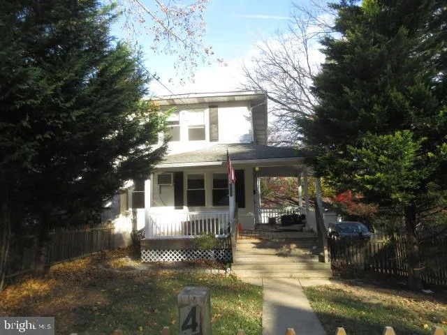 a front view of a house with a yard and potted plants