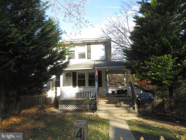 a front view of a house with a yard and potted plants