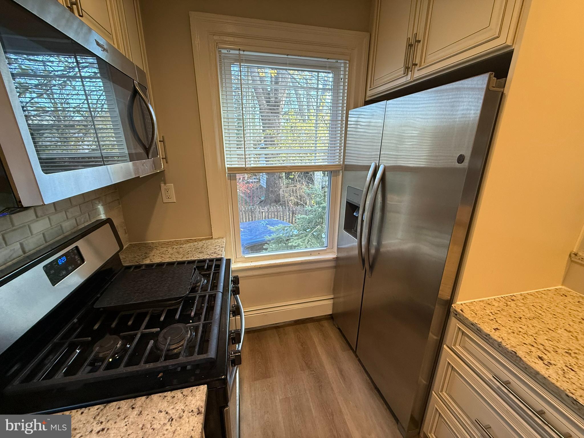 407 West Waverly Road Glenside, PA 19038 - Photo 7 of 23 a kitchen with a refrigerator a stove and wooden cabinets