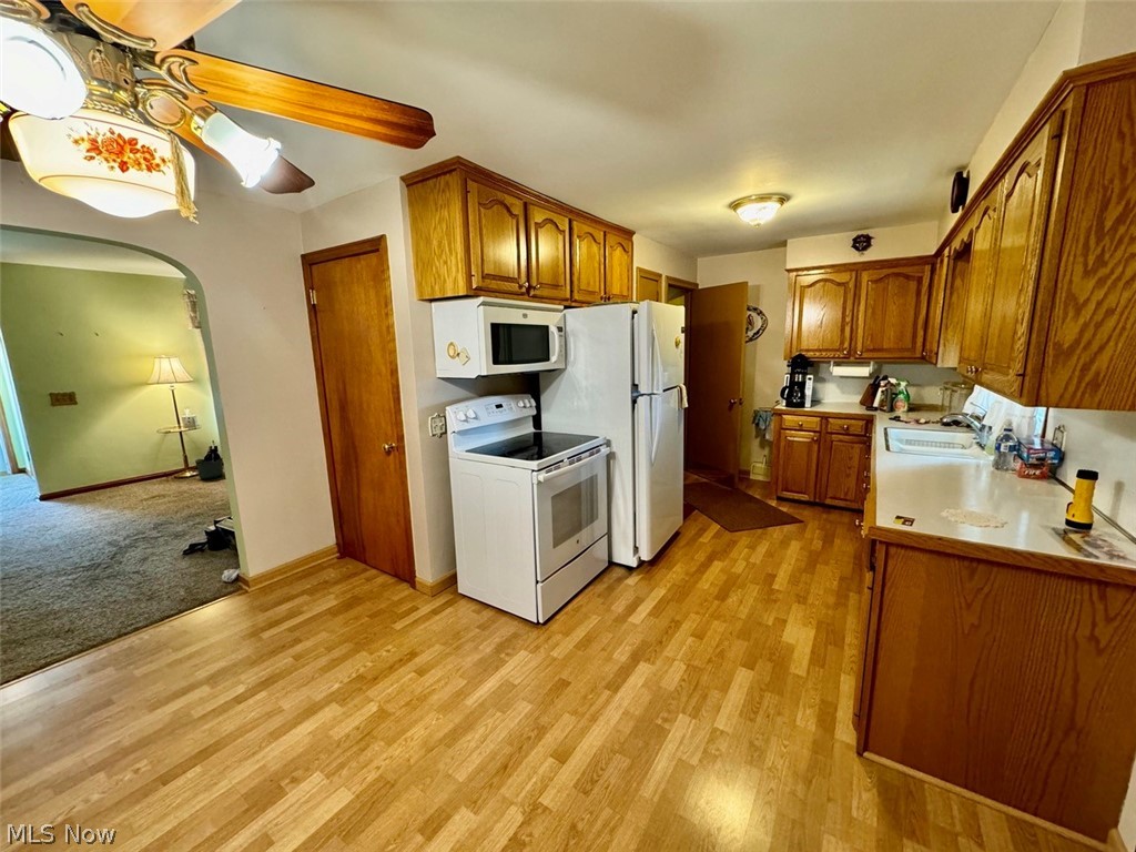 4426 2nd Street Northwest Canton, OH 44708 - Photo 14 of 20 Kitchen with white appliances, sink, ceiling fan, and light hardwood / wood-style flooring