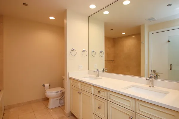 a bathroom with a sink a toilet and a large mirror