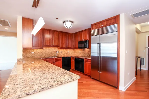 a kitchen with stainless steel appliances granite countertop a refrigerator and a stove top oven