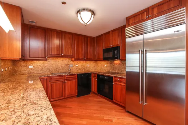 a kitchen with stainless steel appliances granite countertop a stove a sink and a refrigerator