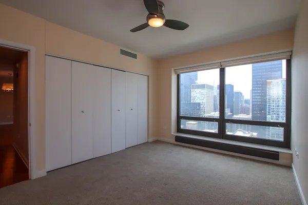 a view of an empty room with a fireplace and a window