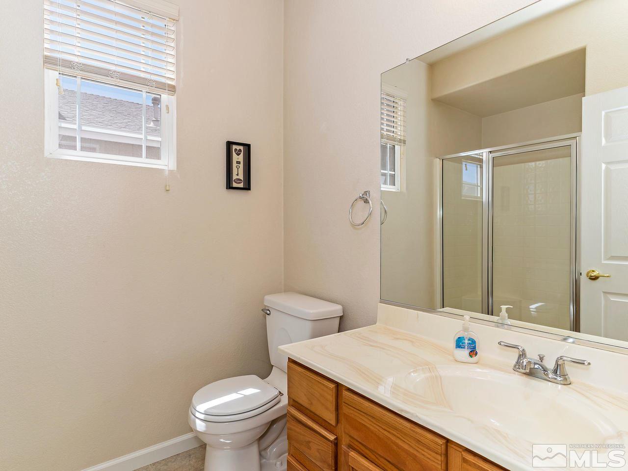 8976 Wynne Street Reno, NV 89506 - Photo 16 of 24 a bathroom with a sink a toilet and a mirror