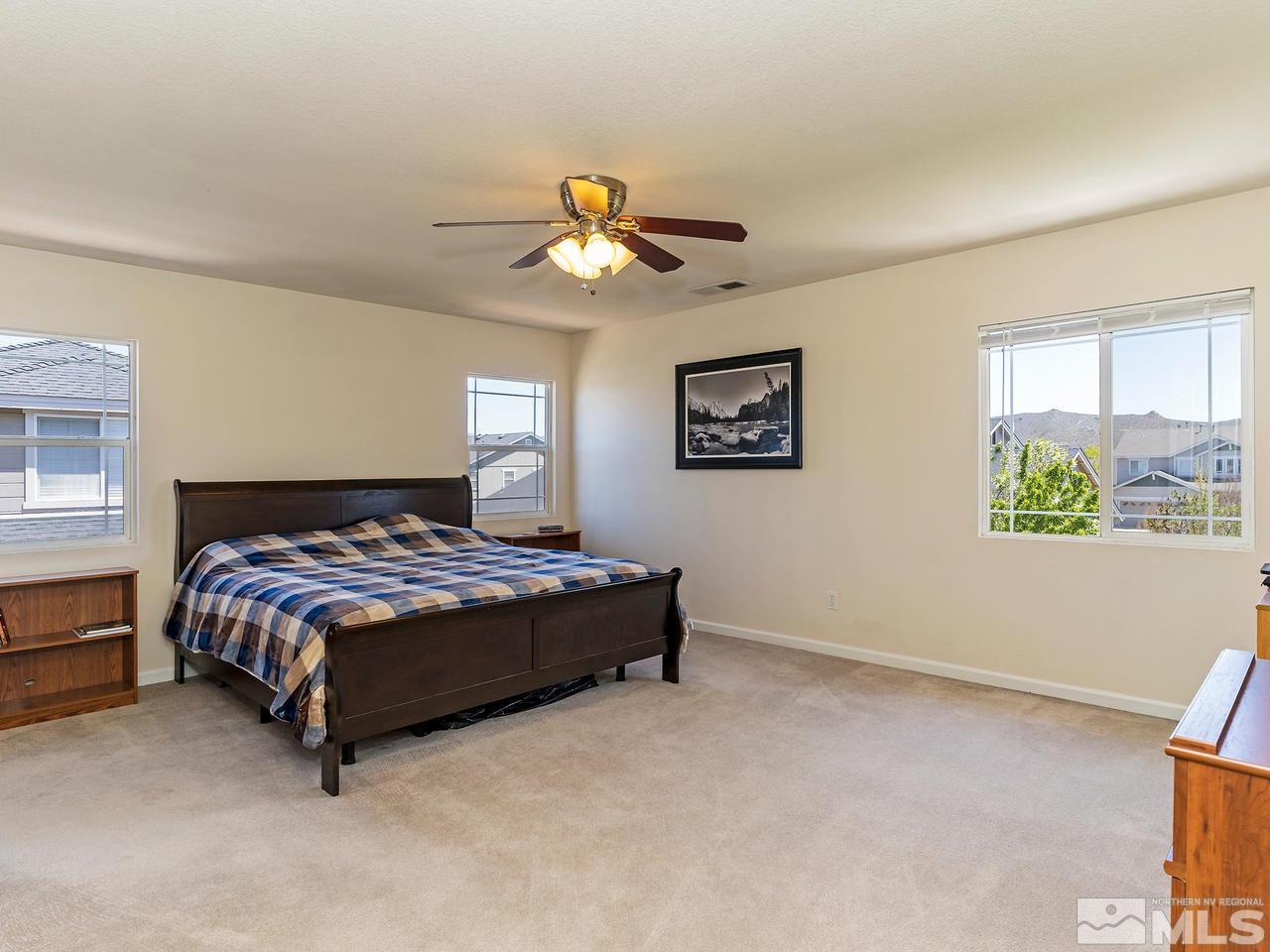 8976 Wynne Street Reno, NV 89506 - Photo 18 of 24 a bedroom with a bed lamp and a chandelier