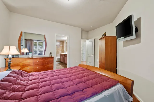 a bedroom with a bed and flat screen tv