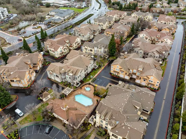an aerial view of a house with a couple of cars parked in yard