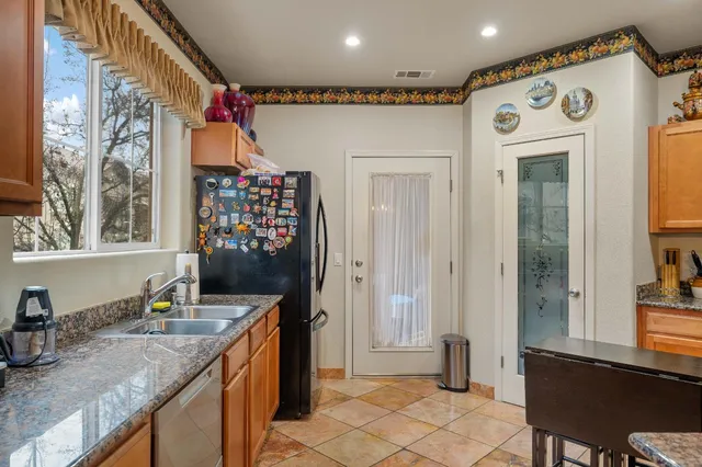 a kitchen with granite countertop a sink and a refrigerator