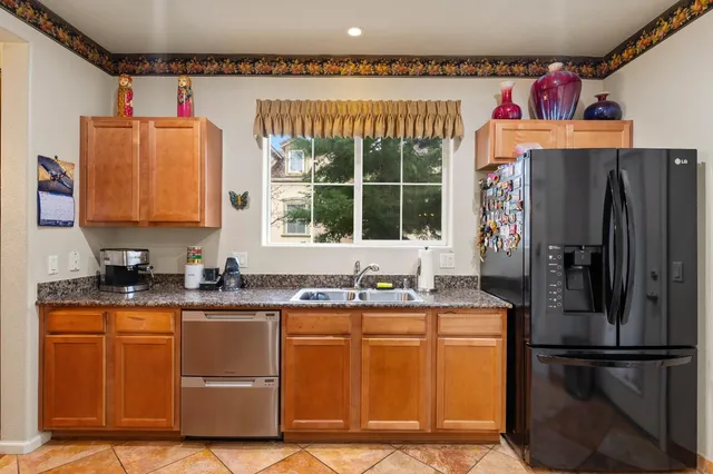 a kitchen with stainless steel appliances granite countertop a refrigerator and a sink