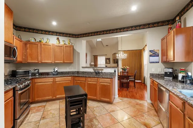 a kitchen with stainless steel appliances granite countertop a refrigerator stove microwave and sink