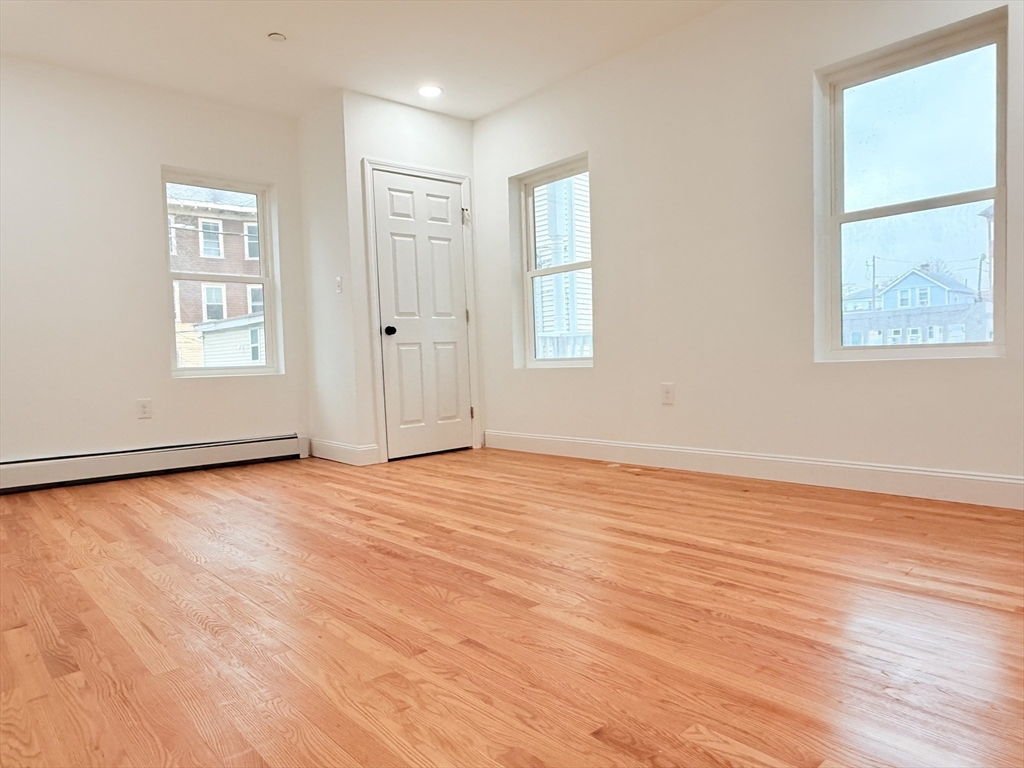 23 Bellevue Street, Unit 1 Worcester, MA 01609 - Photo 14 of 22 an empty room with wooden floor and windows