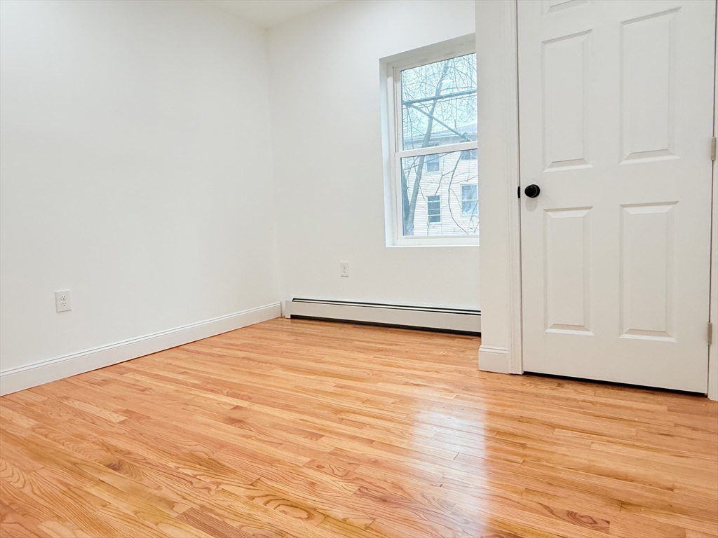 23 Bellevue Street, Unit 1 Worcester, MA 01609 - Photo 16 of 22 a view of an empty room with wooden floor and a window