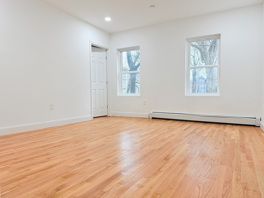 23 Bellevue Street, Unit 1 Worcester, MA 01609 - Photo 6 of 22 an empty room with wooden floor and windows