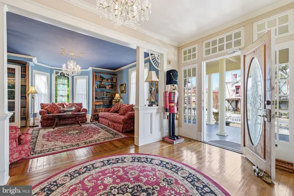 a living room with furniture a chandelier and a rug