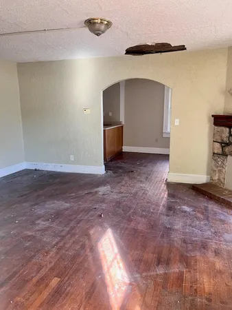 a view of a big room with wooden floor and windows