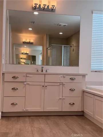 a bathroom with a sink vanity and mirror