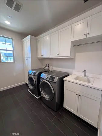 a utility room with sink dryer and washer