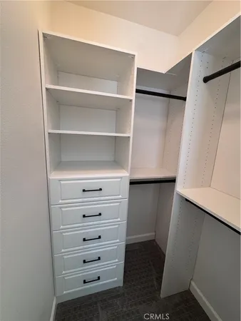 a view of walk in closet with empty racks