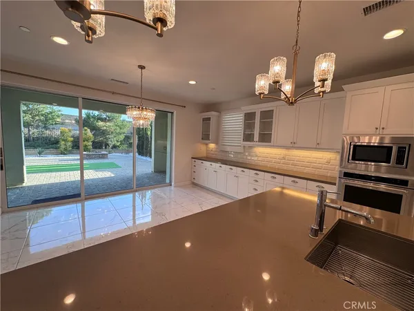 a view of a room with kitchen island wooden floor and fan