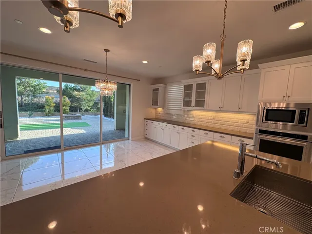a view of a room with kitchen island wooden floor and fan