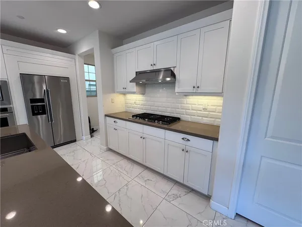 a kitchen with granite countertop white cabinets and stainless steel appliances