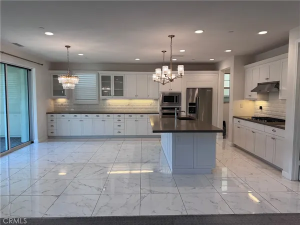a large kitchen with kitchen island a sink stainless steel appliances and a counter top