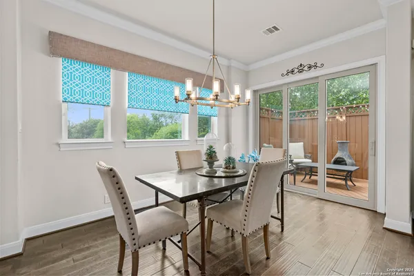 a dining room with furniture a chandelier and wooden floor