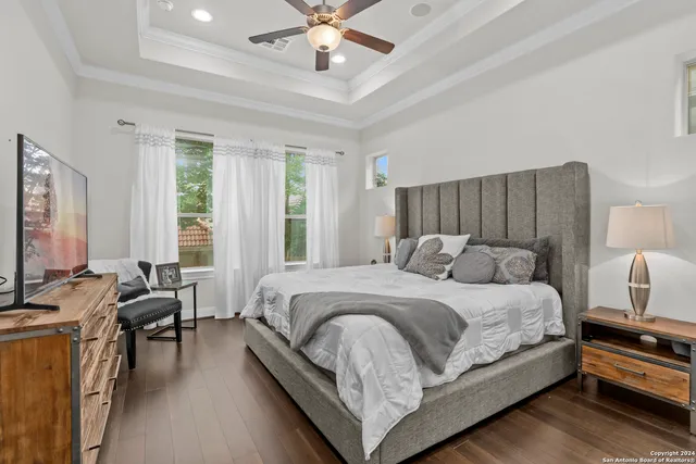 a large bedroom with a bed and wooden floor
