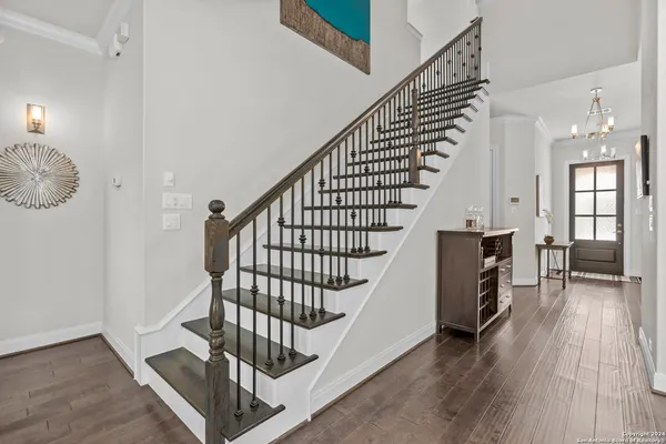a view of staircase with wooden floor and a chandelier
