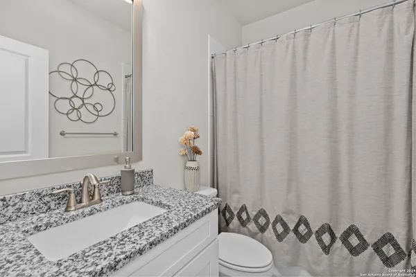 a bathroom with a granite countertop sink and a mirror
