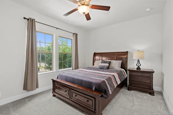 a bed sitting in a spacious bedroom next to a window