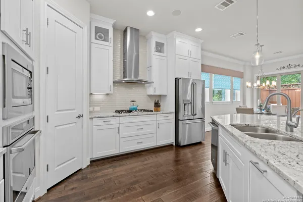 a kitchen with white cabinets and stainless steel appliances