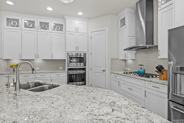 a kitchen with stainless steel appliances white cabinets and a sink