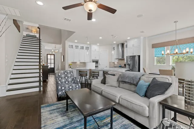 a living room with furniture kitchen and a chandelier