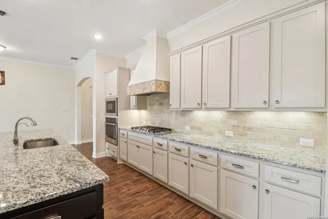 a kitchen with granite countertop white cabinets and a stove