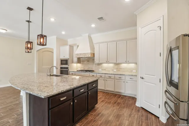 a kitchen with a sink a counter space cabinets and appliances