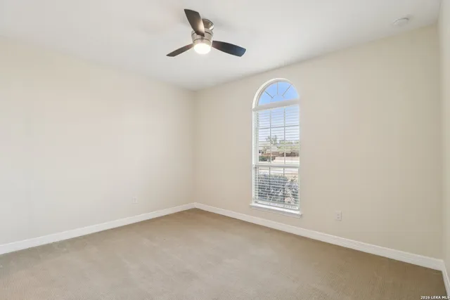 an empty room with a window and ceiling fan