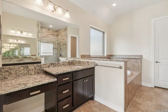 a bathroom with a granite countertop sink and a mirror