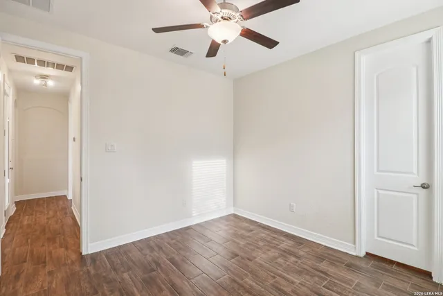 an empty room with wooden floor a ceiling fan and closet