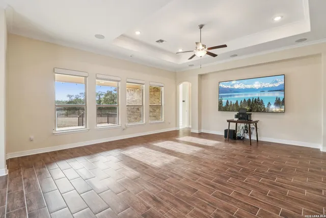 a view of empty room with a window and wooden floor