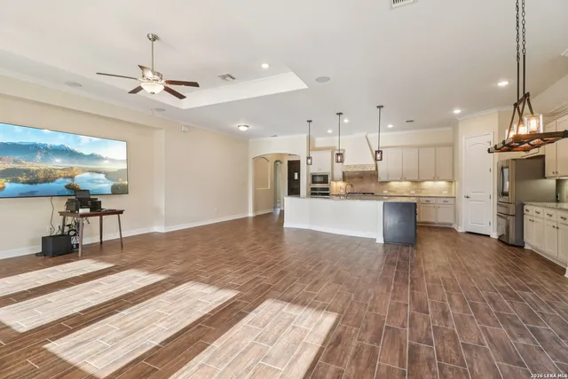 a large white kitchen with a large window a sink and stainless steel appliances