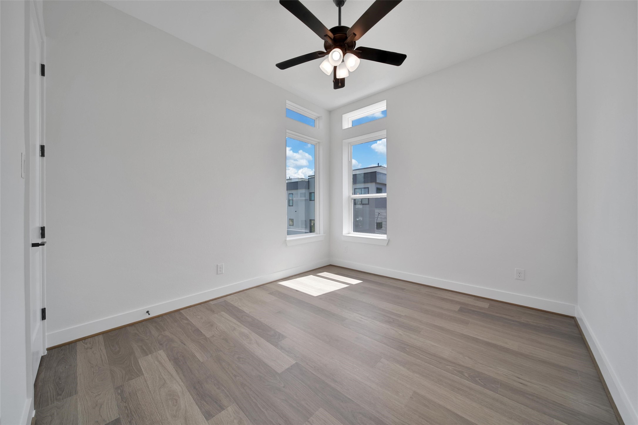 4404 Anthony Court Lane Seabrook, TX 77586 - Photo 19 of 36 an empty room with wooden floor chandelier fan and windows
